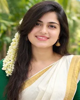Meera in a cream saree with a green blouse, jasmine tucked behind one ear